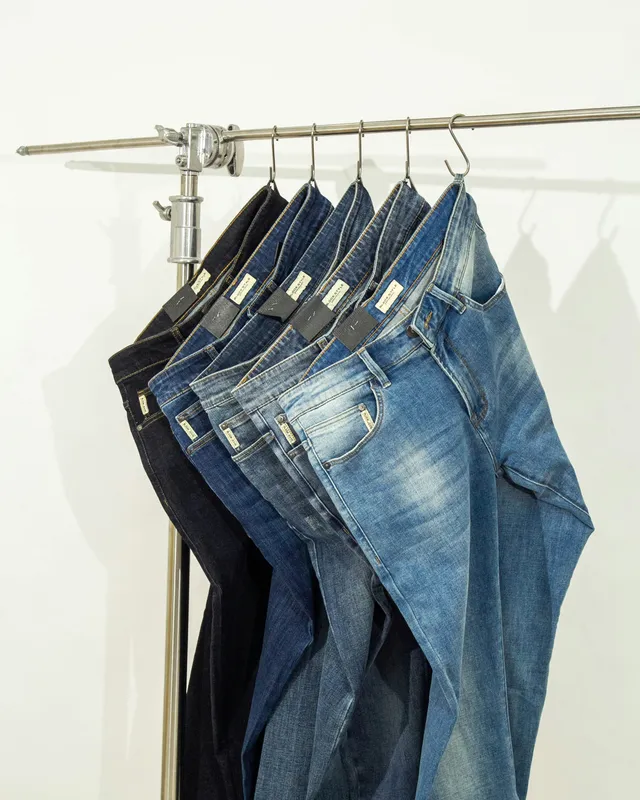 Jeans en tonos índigo colgados en un perchero metálico